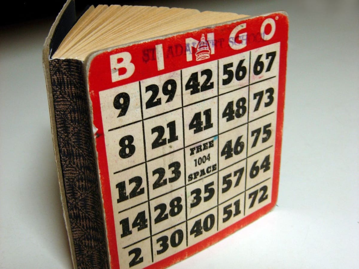 A small book whose cover is an old red and white bingo card with a free space in the middle