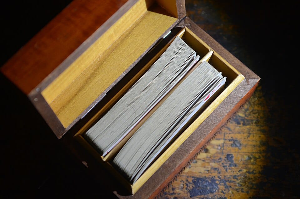 Two packs of playing cards side by side in an open wooden box
